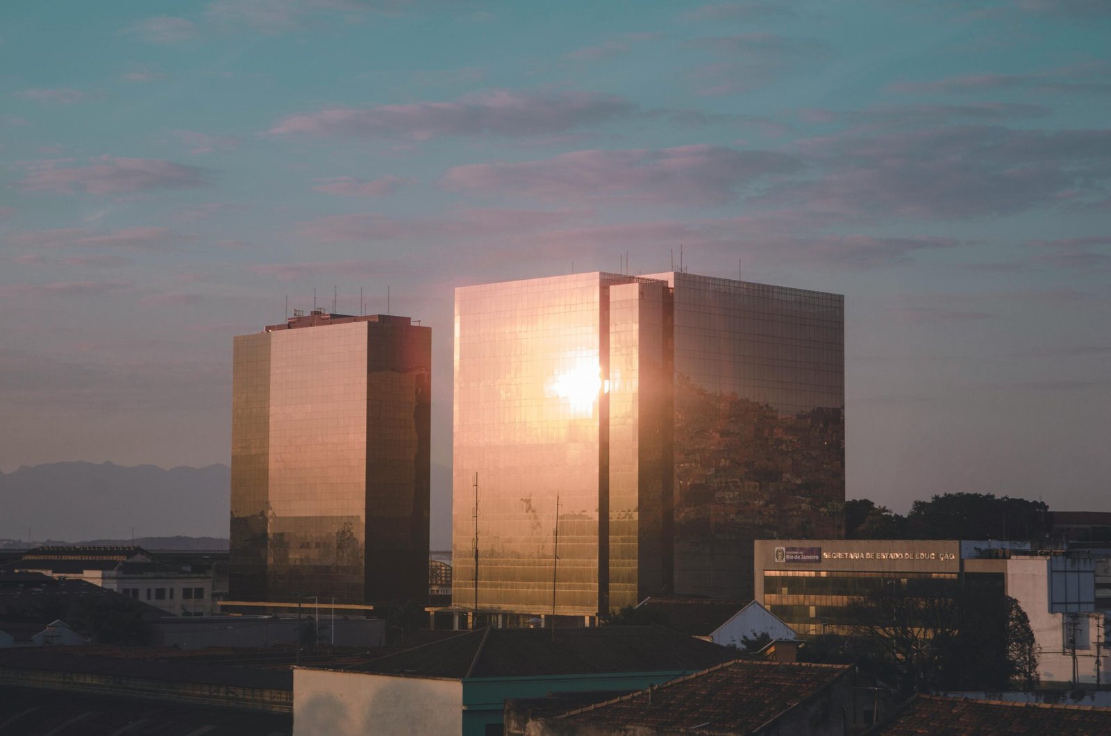 Sunset light reflects on modern glass skyscrapers in Rio de Janeiro, creating a stunning visual effect.